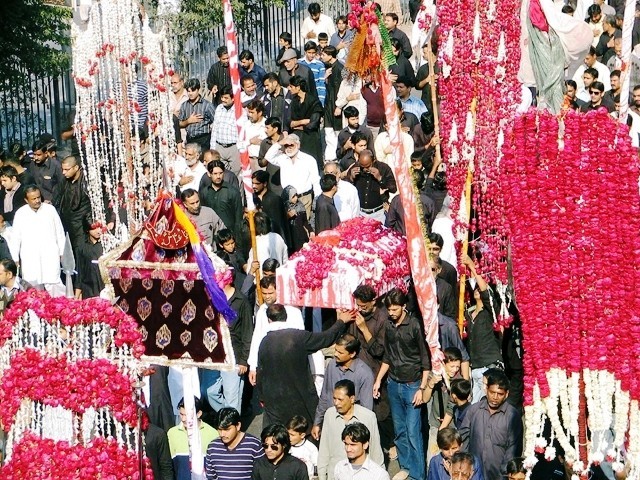 Use of alams in a Pakistani Ashura celebration in Karachi. Similar to Dezfuli processions, some men individually hold an alam as they walk.