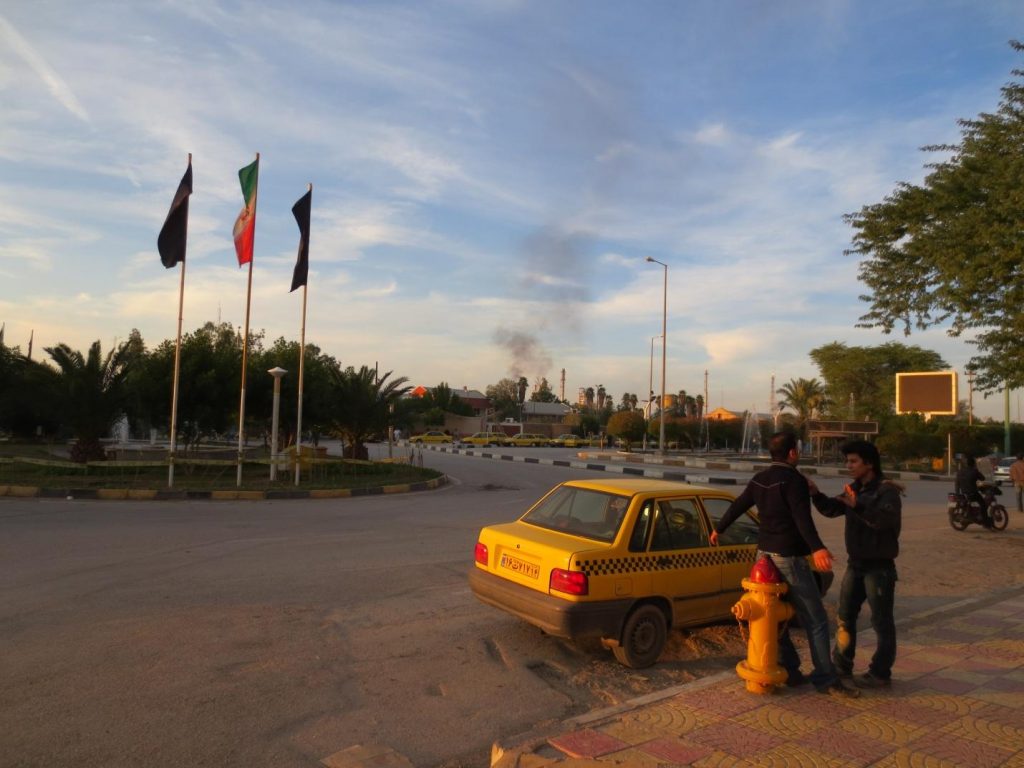 Sunset near Abadan, with the smoke plumes of the oil refinery in the background.
